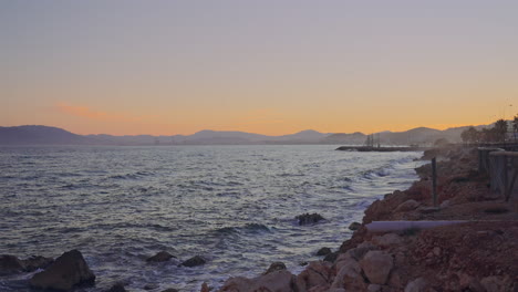 smooth soft coastline sunset with mountain silhouette on the background