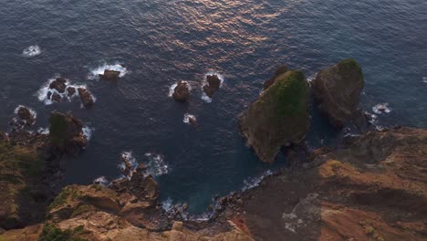 Volar-Sobre-Las-Olas-Del-Océano-Rompiendo-En-Los-Acantilados-De-Las-Islas-Azores,-Aéreo