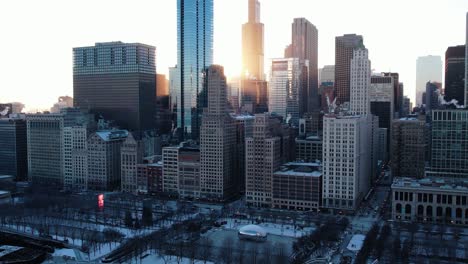 sol passando por prédios ao pôr do sol em chicago, illinois, eua