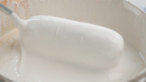 mixing white paint in a bucket