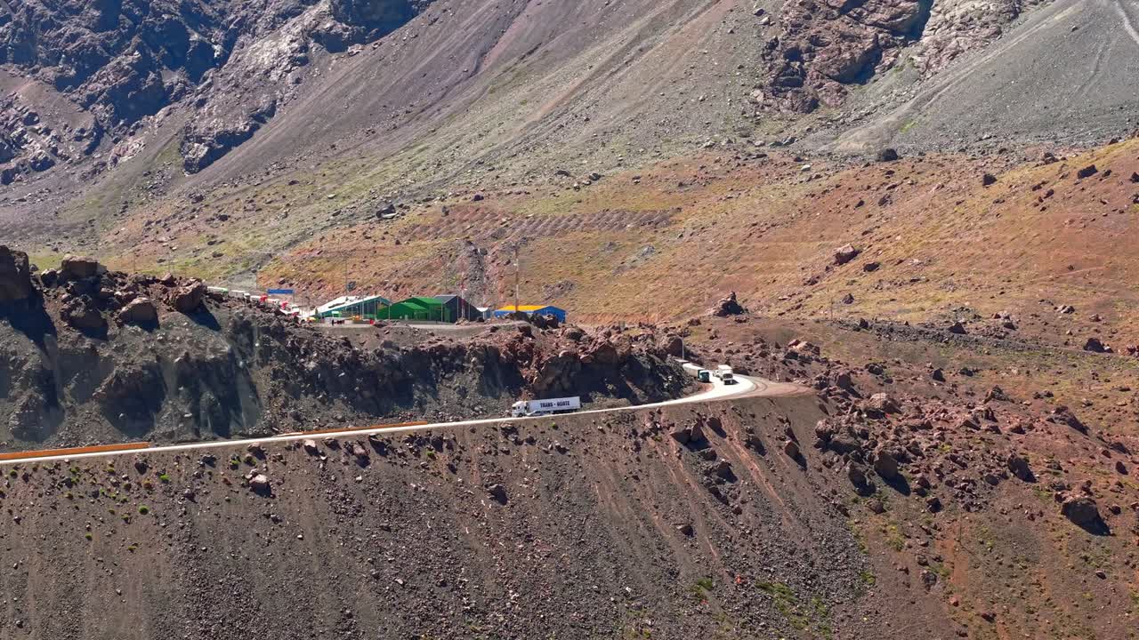 Vista aerea da teleobiettivo di un camion cargo che scende da Portillo, in Cile, al valico di frontiera tra Cile e Argentina