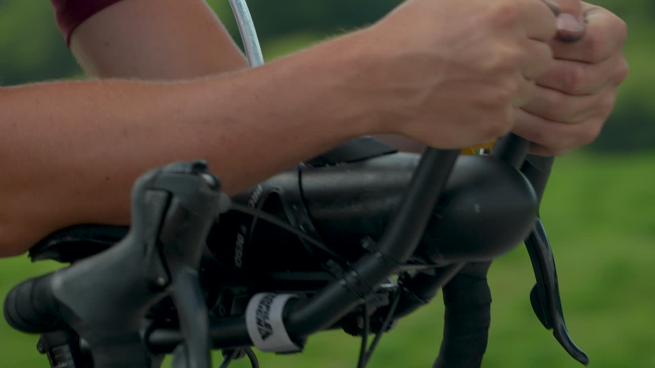 Close-up of a cyclist's hand resting on the handlebars