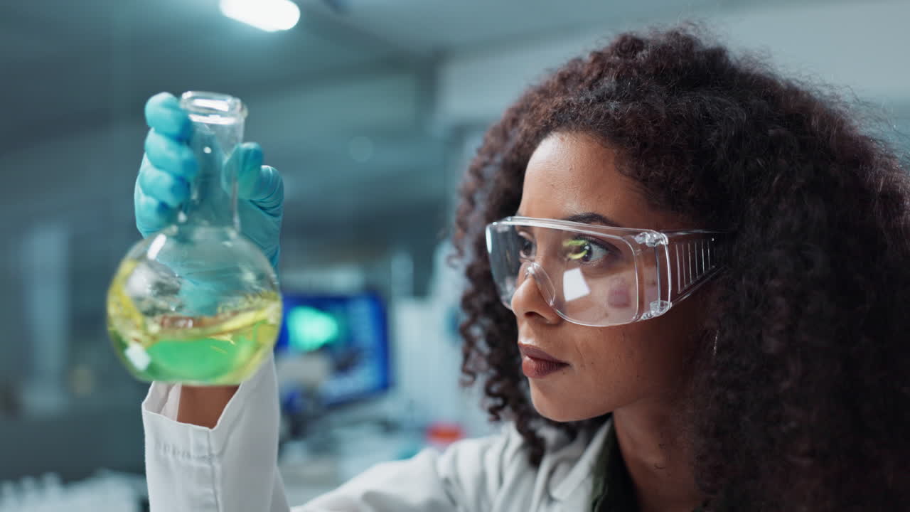 실험실 환경에서 병을 검사하는 과학자