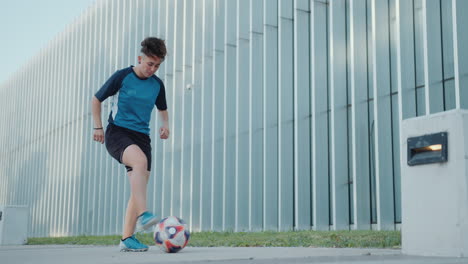 female athlete juggling a soccer ball outdoors in the city