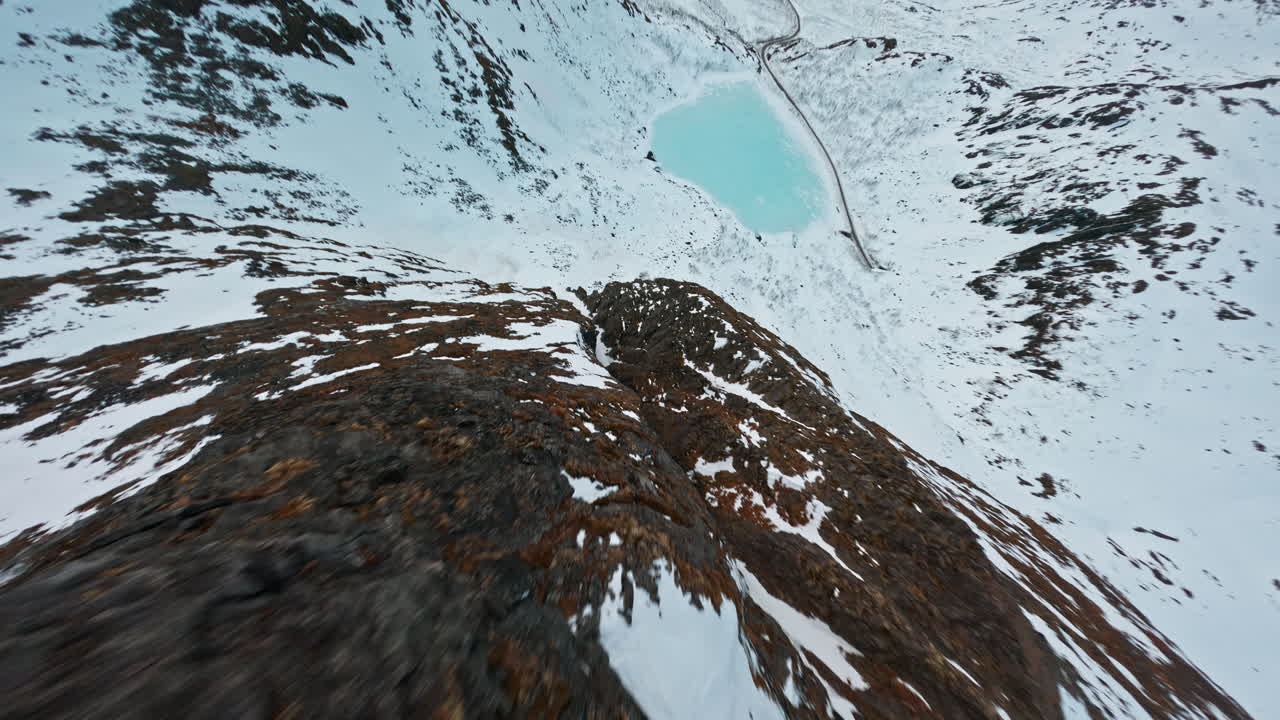 Snow-covered mountain ridge on Senja Island, rugged terrain under a cloudy sky