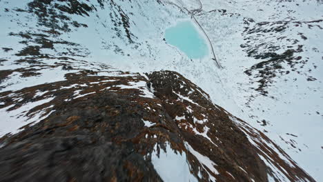 snow-covered mountain ridge on senja island, rugged terrain under a cloudy sky