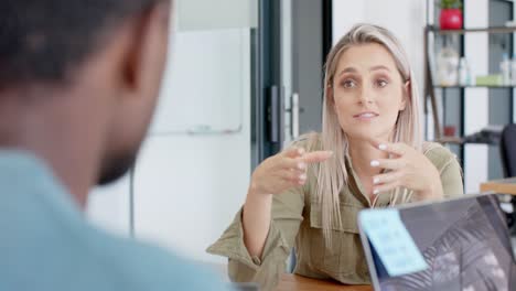 busy diverse business people discussing work at table with tablet in slow motion