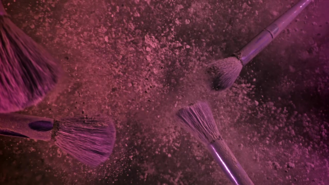 Makeup Brushes Covered in Pink Powder Dispersing in Slow Motion