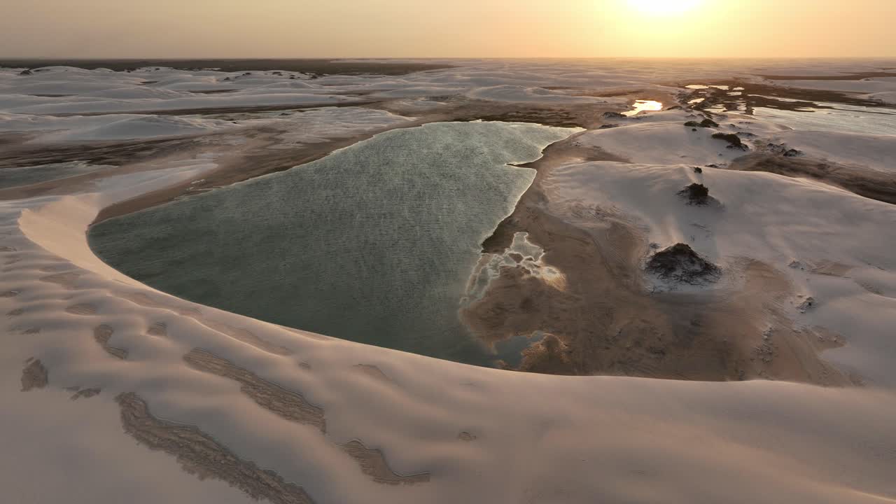 Lençóis Maranhenses at sunset or sunrise, with vibrant skies and vast sand dunes creating magic.