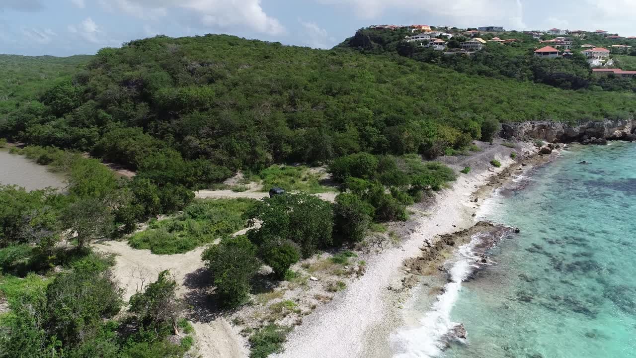conducción de automóviles fuera de la carretera hasta la costa olas rompiendo montañas y vegetación río de agua clara del océano