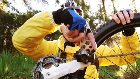 un ciclista de montaña reparando su bicicleta