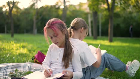 two girls drawing in a park