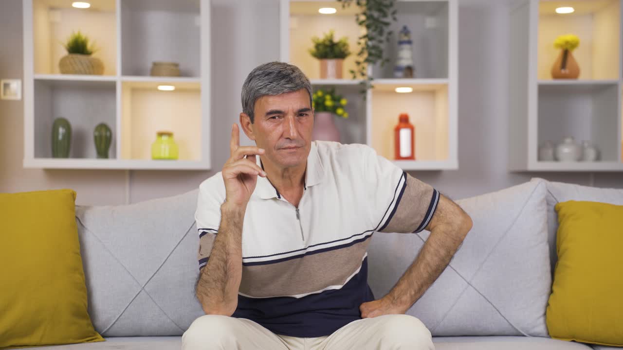 un anciano mirando negativamente a la cámara.