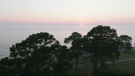 Wunderschöne-Luftaufnahme-Eines-Lebendigen,-Kontrastreichen-Sonnenuntergangs-über-Der-Ruhigen-Ostsee,-Wolken-Am-Horizont,-Ruinen-Der-Betonküstenbefestigung-Des-Karosta-Kriegshafens-In-Liepaja,-Weite-Drohnen-Dolly-Aufnahme,-Die-Sich-Nach-Rechts-Bewegt