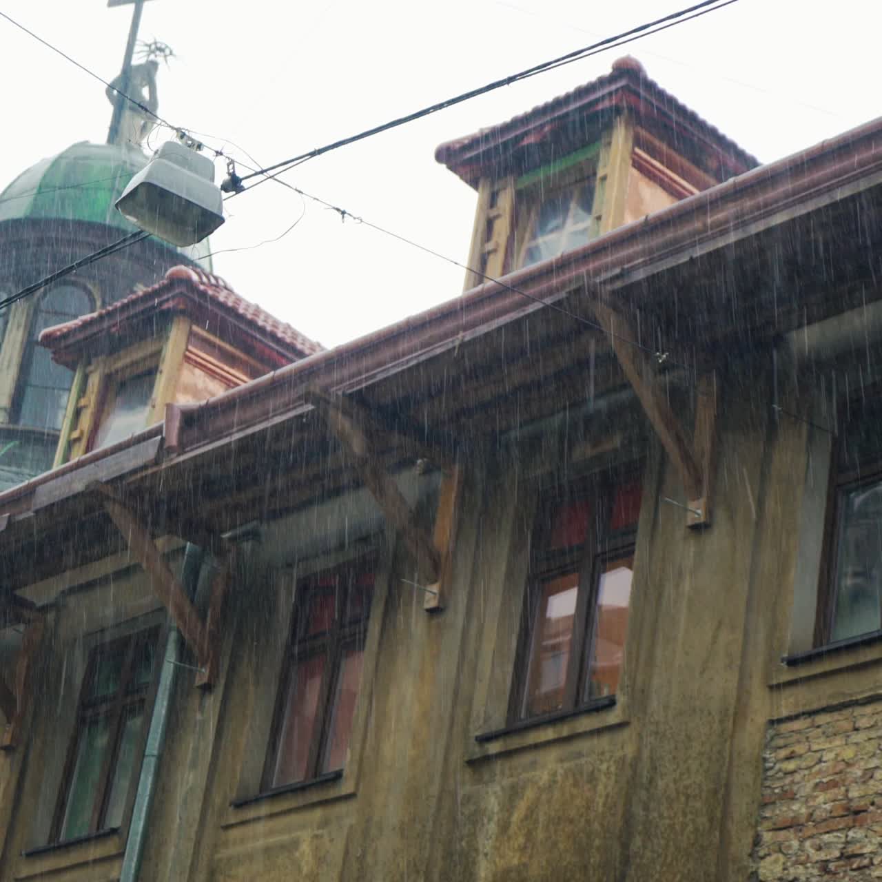 rainfall on the background of urban architecture. Drops of rain are falling on the background of a old building