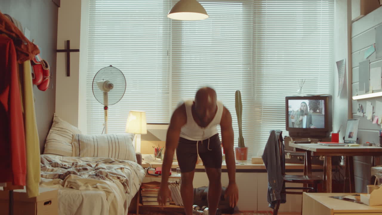 아프리카계 미국인 남자가 집에서 운동을 하고 있습니다.