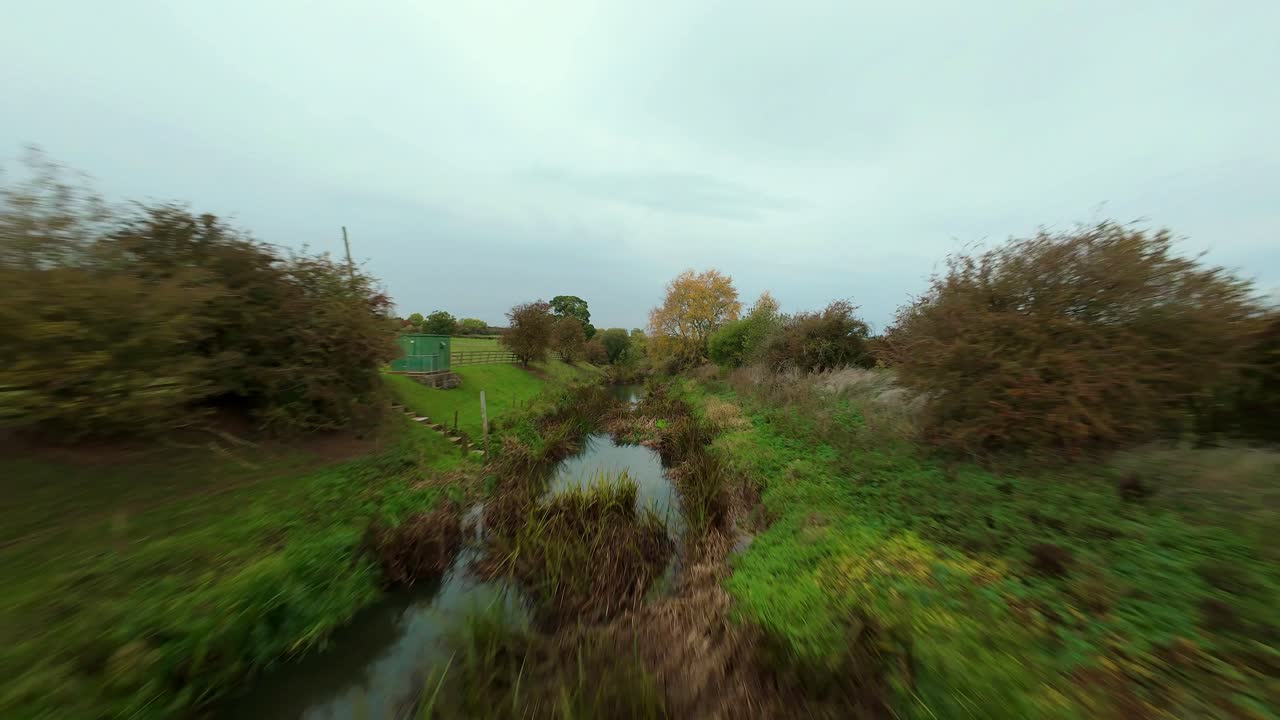 Aerial FPV drone video of Brooke Reservoir in Rutland capturing wetland habitat, shoreline vegetation and water infrastructure at dusk