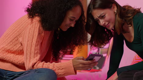 dos mujeres mirando un teléfono