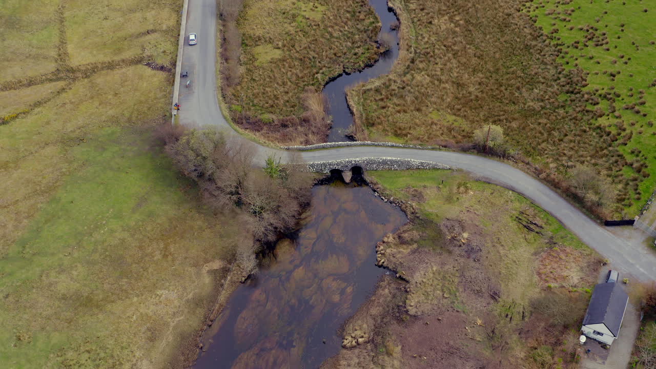 Top-down aerial pullback of The Quiet Man Bridge revealing Connemara landscape