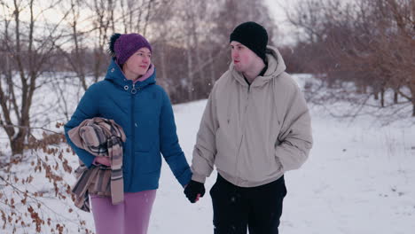 couple walking in snowy park