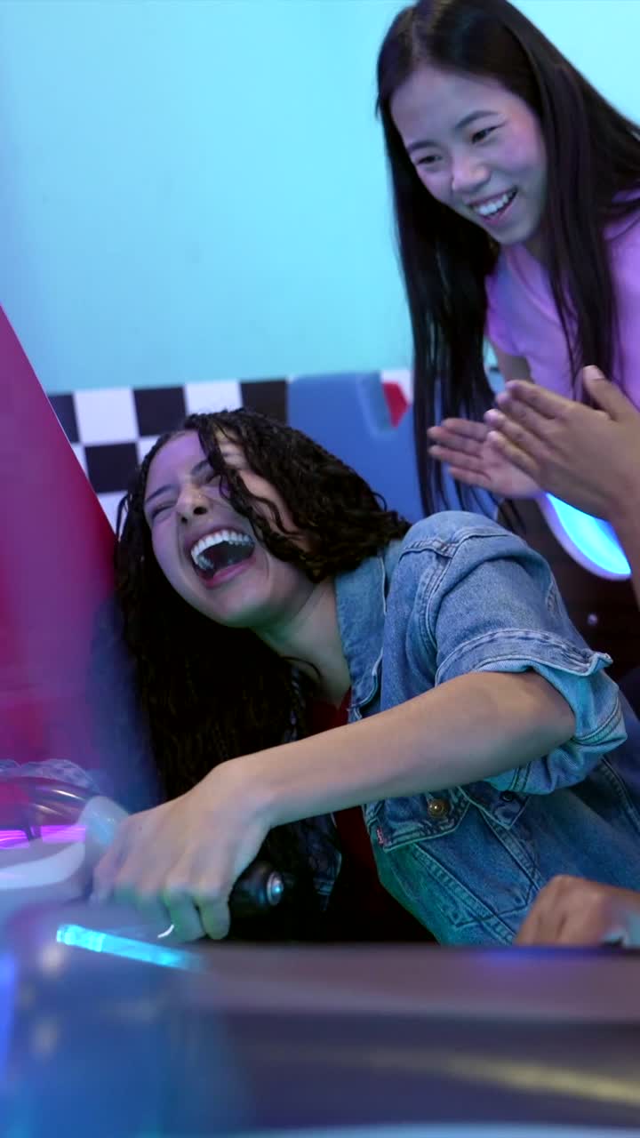 Adolescentes divirtiéndose jugando a un juego arcade de isla pirata