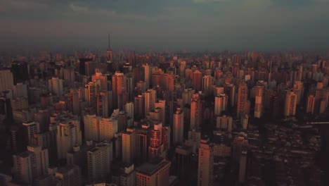 Tilting-aerial-shot-showing-beautiful-pink-cityscape-of-Sao-Paolo,-Brazil-in-perfect-sunset