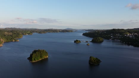 panorámica aérea sobre pequeñas islas con densos árboles boscosos en medio de un amplio río en noruega
