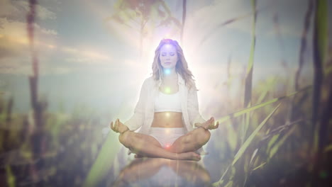 animation of light spots and grass over caucasian woman practicing yoga and meditating