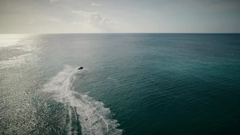 a shot of my friend riding his jet-ski into the horizon on the coast of barbados.