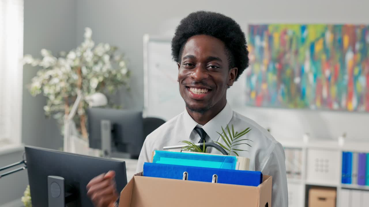 handsome men in white shirt with afro hair quits corporate job, walks out of office with things packed in box, quits corporate, quits responsibilities, retires, leaves social room, happy