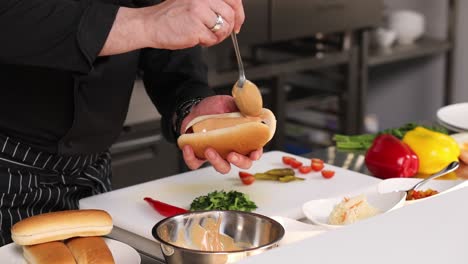 el chef preparando un perrito caliente