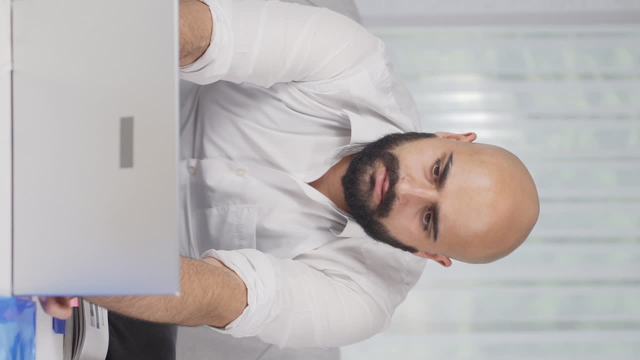 Vertical video of Home office worker man getting good news from camera.