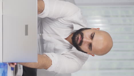 Vertical-video-of-Home-office-worker-man-getting-good-news-from-camera.
