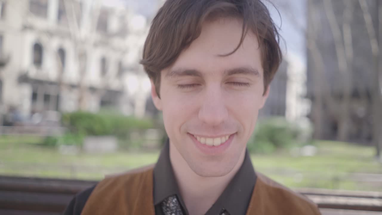 Well dressed businessman adjusts his tie and smiles at the camera