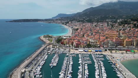 boat marina and soleil bay at seaside town on menton in southern france, aerial flyover shot