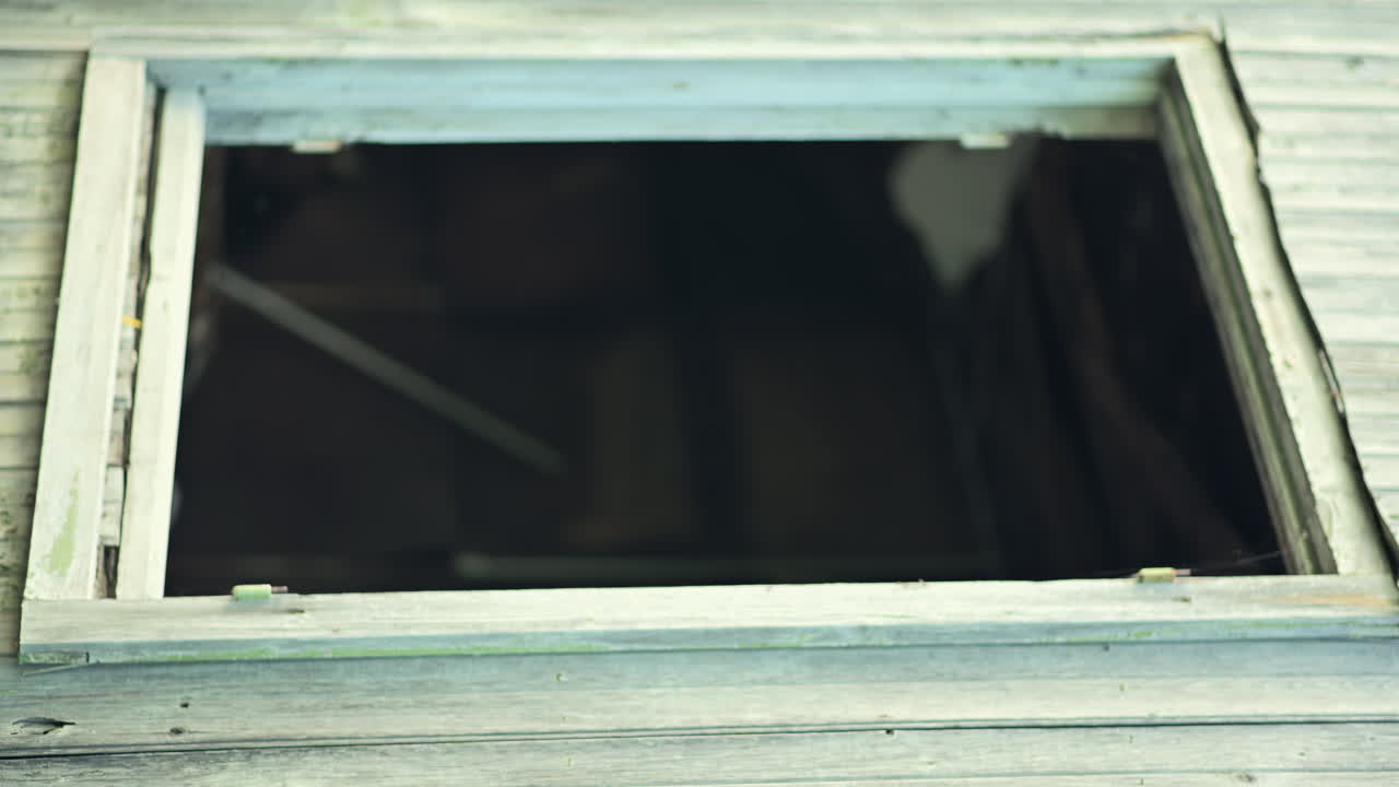 Broken roof window revealing an old, abandoned building interior