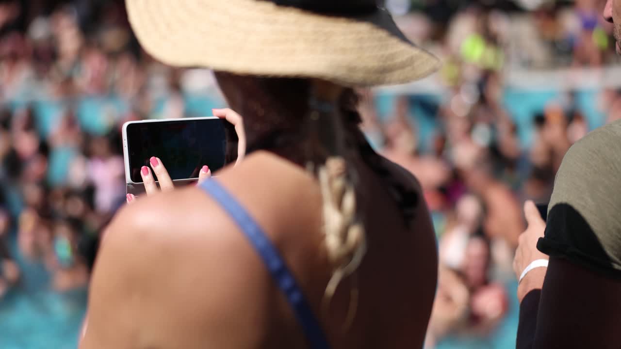 Woman taking pictures at a pool party