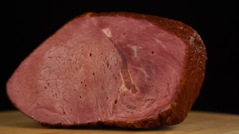 a piece of smoked beef rotates on a black background