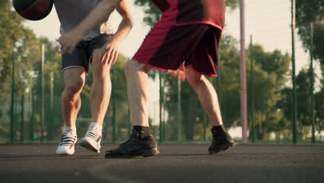 Two-Male-Basketball-Players-Dribbling-In-Outdoor-Basketball-Court