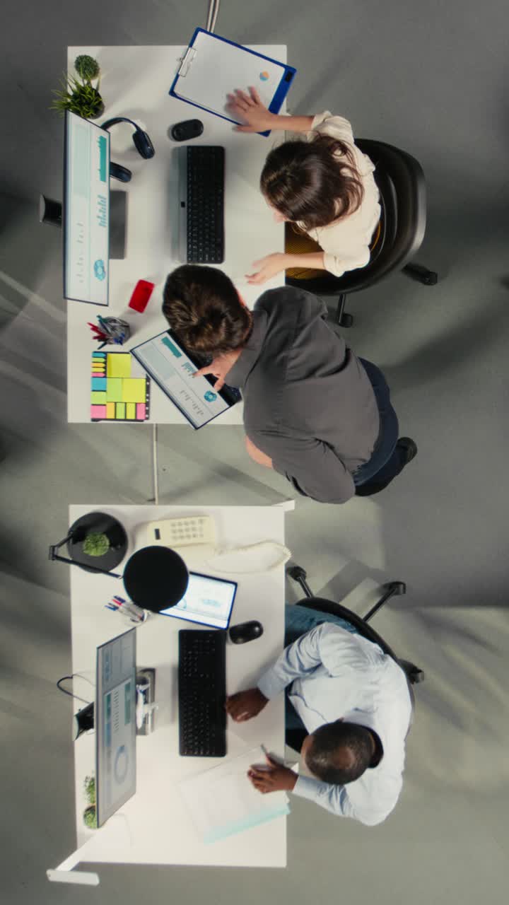 Vertical Video Top down view of employees team discuss business intel and performance