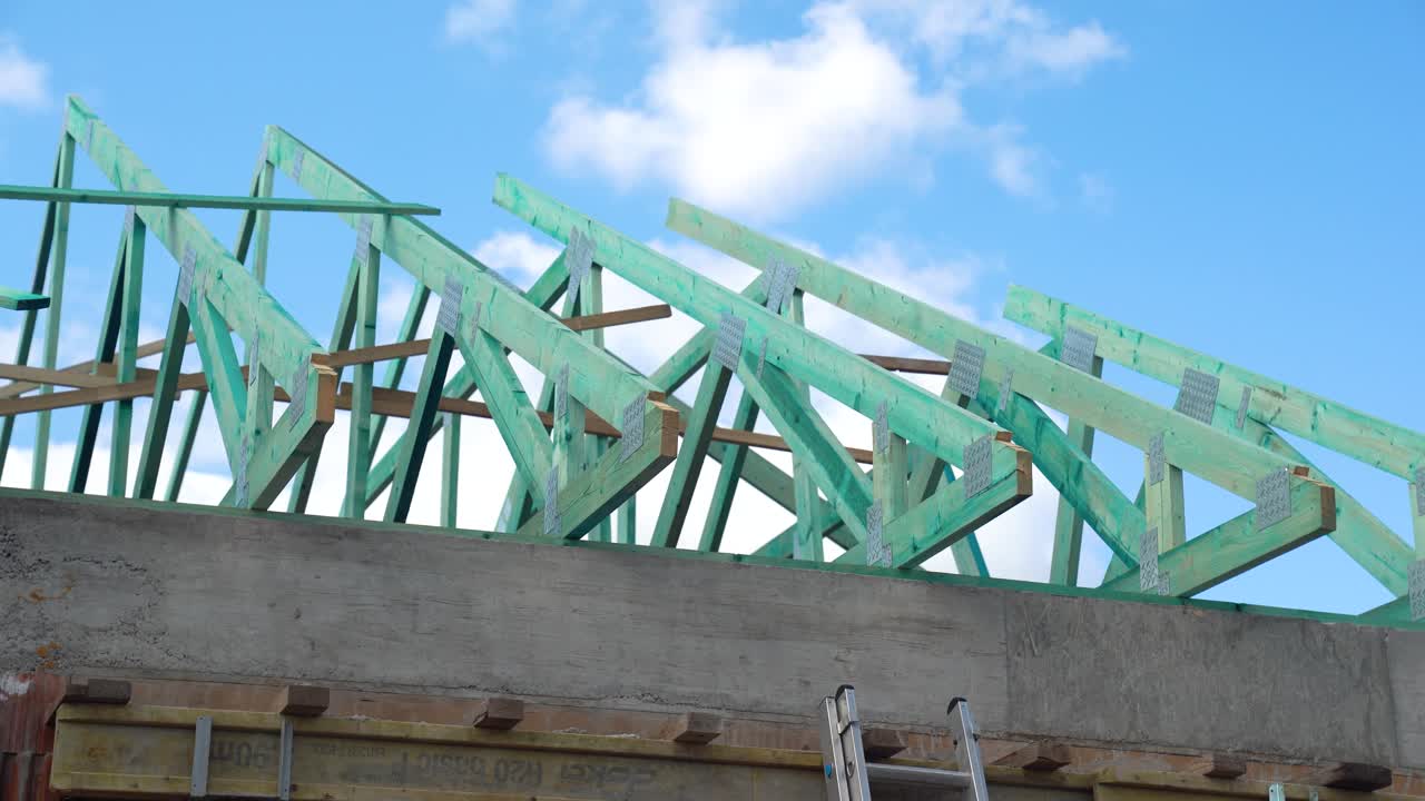 Close-up of impregnated timber roof structure under construction with cloudy sky backdrop