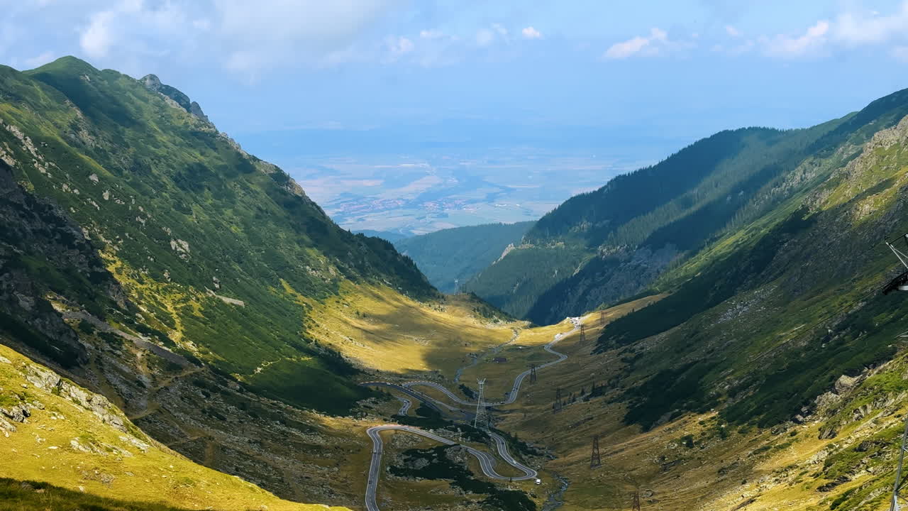Transfagarasan Highway in the Carpathian Mountains. Scenic aerial view of the Transfagarasan mountain road winding through green valleys and peaks in Romania