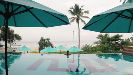 Mujer-En-La-Piscina-Infinita-Disfrutando-De-Un-Estilo-De-Vida-De-Lujo-En-El-Spa-Del-Hotel-Con-Vistas-A-La-Playa