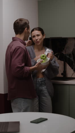 couple eating apples in the kitchen