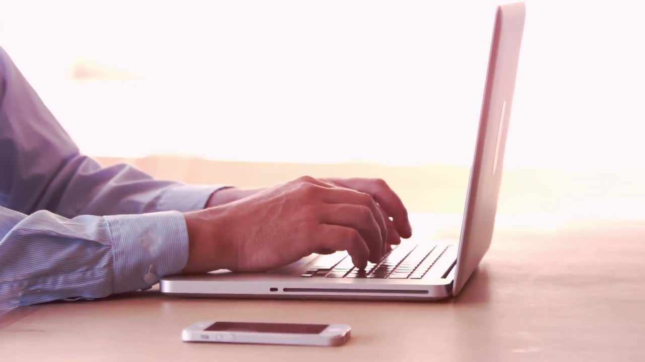 Smiling businessman typing on his laptop