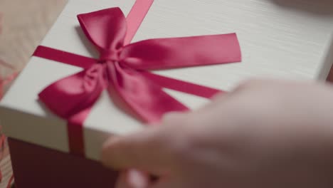 primer plano de hombre regalo envolviendo romántico regalo de san valentín de perfume en caja en la mesa 3