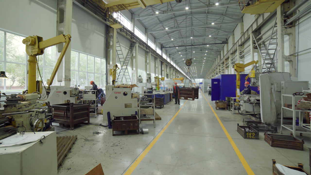 Interior de fábrica con maquinaria y trabajadores