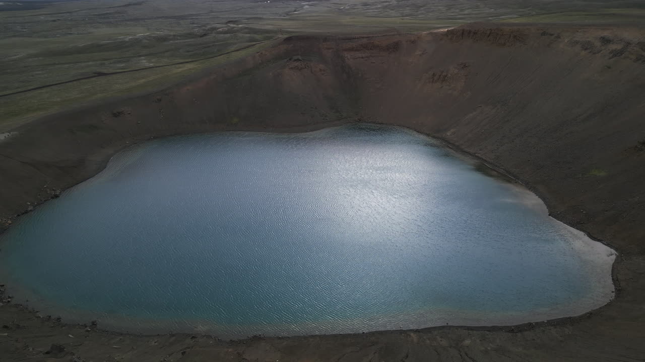 Aerial panoramic pullback over Krafla Viti Crater stunning blue water