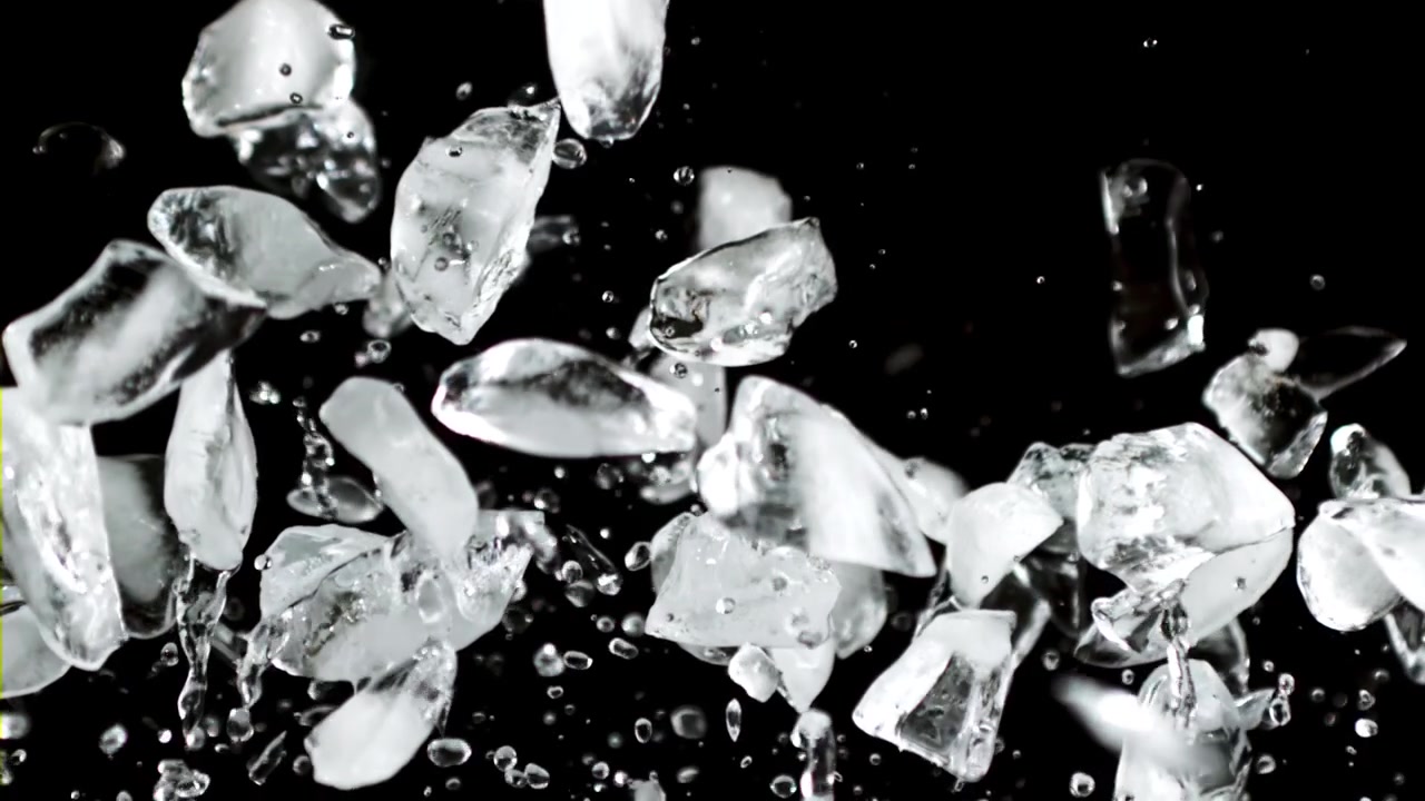 Cubetti di ghiaccio trasparenti e acqua che schizzano verso l'alto al rallentatore