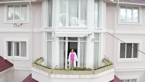 woman on a balcony of a large house